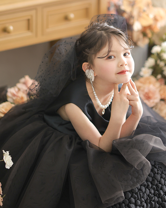 黒いチュールのドレスにパールのネックレスをつけた女の子